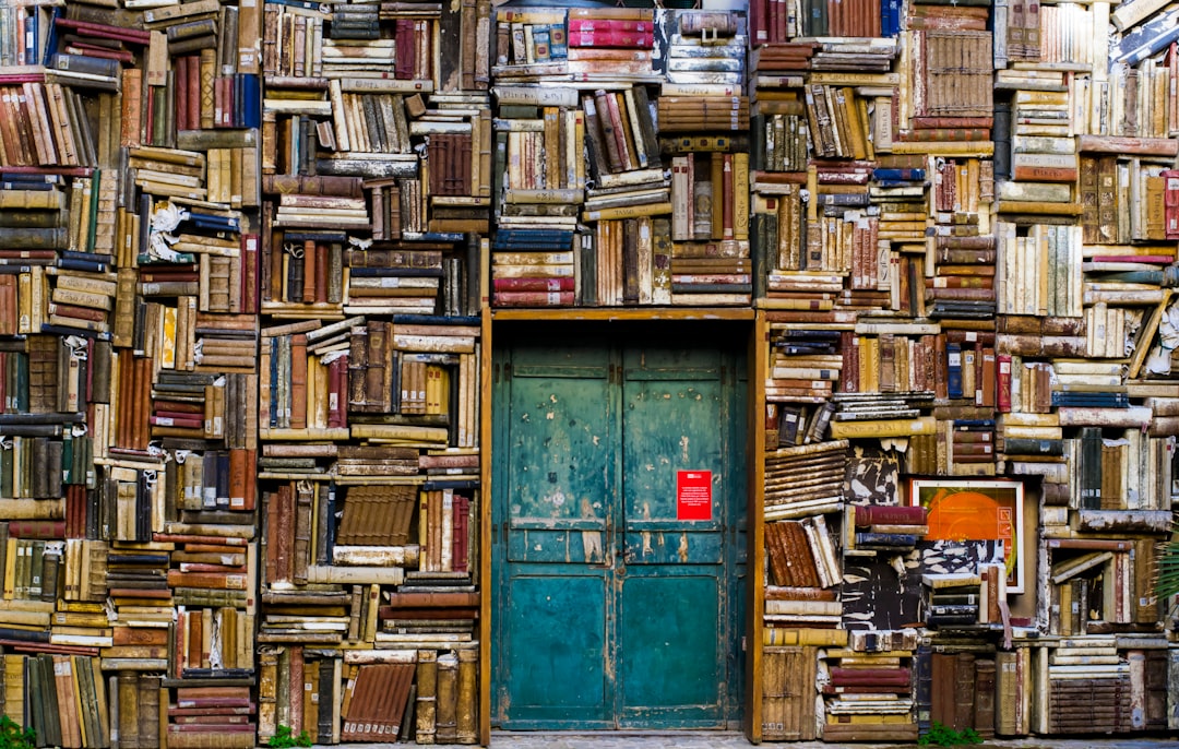 Book-covered walls by Dream and Meaning blue wooden door surrounded by book covered wall