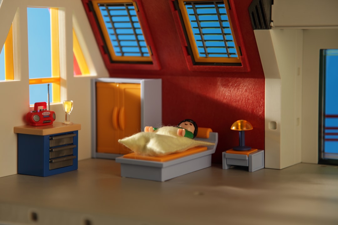 A playmobil guy peacefully sleeping in his loft apartment. by Dream and Meaning white and brown wooden table