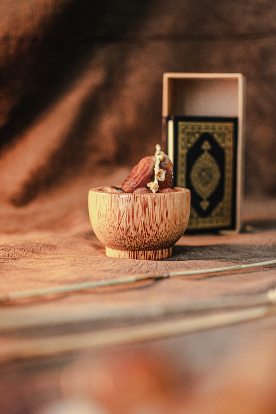 Quran behind dates by Dream and Meaning a small wooden bowl with a small figurine in it